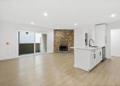 Thumbnail 2 of 12 - a living room with a kitchen and a fireplace