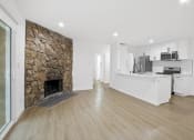 Thumbnail 3 of 12 - a living room with a fireplace and a kitchen