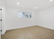 Thumbnail 6 of 12 - a living room with white walls and a window