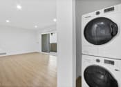 Thumbnail 4 of 12 - a washer and dryer in a room with a wood floor and a white