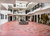 Thumbnail 3 of 4 - A courtyard with a red tile floor and a fountain in the middle.