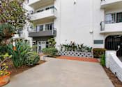 Thumbnail 4 of 4 - A white building with a balcony and a small garden in front.