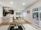 Thumbnail 2 of 32 - A modern kitchen with a dining table and chairs.