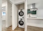 Thumbnail 7 of 32 - A white laundry machine is in a small, modern room.
