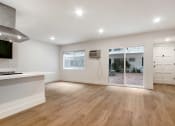 Thumbnail 5 of 32 - an empty living room and kitchen with a sliding glass door to a patio