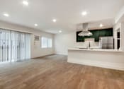 Thumbnail 4 of 29 - A kitchen with a white counter and wooden floors.