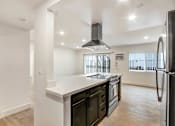 Thumbnail 6 of 29 - A modern kitchen with a black fridge and stove.