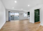 Thumbnail 20 of 32 - A spacious room with wooden flooring and white walls.
