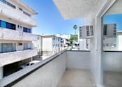 Thumbnail 21 of 32 - A white building with a balcony overlooking a street.