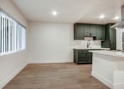Thumbnail 13 of 32 - A kitchen with a white counter and wooden floors.