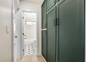 Thumbnail 17 of 32 - A bathroom with a white door and a green cabinet.