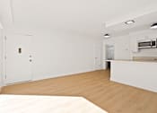 Thumbnail 3 of 21 - A kitchen with white cabinets and a wooden floor.