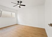 Thumbnail 5 of 21 - A room with a ceiling fan and a window.