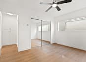 Thumbnail 6 of 21 - A room with a ceiling fan and a mirror on the wall.