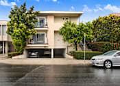 Thumbnail 8 of 21 - A two-story beige house with a balcony on the second floor.