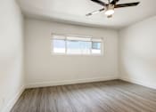 Thumbnail 11 of 21 - A room with a ceiling fan and a window.
