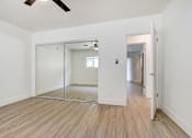 Thumbnail 12 of 21 - A room with a sliding door and a ceiling fan.