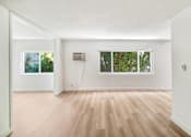 Thumbnail 16 of 23 - A room with wooden floors and white walls.