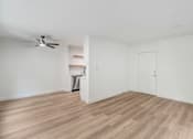 Thumbnail 15 of 23 - A room with a fan and a wooden floor.