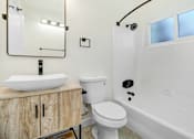 Thumbnail 21 of 23 - A white bathroom with a sink, toilet and bathtub.
