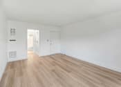 Thumbnail 7 of 23 - A room with wooden flooring and white walls.