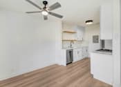Thumbnail 3 of 23 - A room with a ceiling fan and wooden flooring.