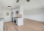 Thumbnail 2 of 23 - A kitchen with white cabinets and a stainless steel refrigerator.