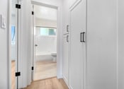 Thumbnail 8 of 23 - A white door with a black handle is open.