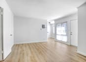 Thumbnail 6 of 17 - A room with wooden floors and white walls.