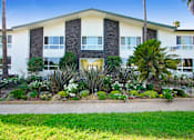 Thumbnail 14 of 17 - A building with a green lawn in front of it.