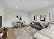 Thumbnail 2 of 21 - A well-lit bedroom with a large bed and a separate sitting area.