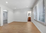 Thumbnail 9 of 22 - A room with wooden floors and white walls.