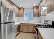 Thumbnail 10 of 22 - A modern kitchen with wooden cabinets and a stainless steel refrigerator.