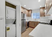 Thumbnail 11 of 22 - A modern kitchen with a white countertop and stainless steel appliances.