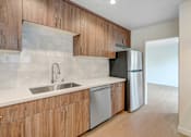 Thumbnail 4 of 22 - A kitchen with wooden cabinets and a white countertop.