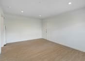 Thumbnail 5 of 22 - A room with wooden flooring and white walls.