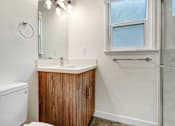 Thumbnail 7 of 22 - A bathroom with a toilet, sink, and shower.