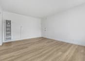 Thumbnail 16 of 22 - A room with wooden flooring and white walls.