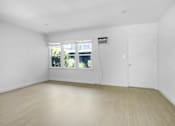 Thumbnail 11 of 21 - A room with a white door and a window with blinds.