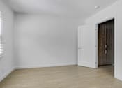Thumbnail 17 of 21 - A room with a white door and a window with blinds.
