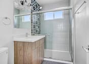 Thumbnail 18 of 21 - A bathroom with a walk-in shower and a toilet.