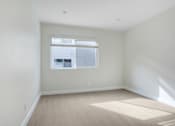 Thumbnail 17 of 37 - A room with a window and wooden flooring.