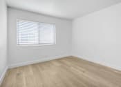 Thumbnail 4 of 37 - A room with wooden flooring and a window with blinds.