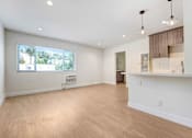 Thumbnail 20 of 37 - A spacious room with wooden flooring and a large window.