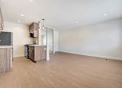 Thumbnail 23 of 37 - A spacious kitchen with wooden floors and white walls.