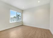 Thumbnail 24 of 37 - A room with a window and wooden flooring.