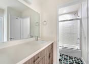 Thumbnail 26 of 37 - A bathroom with a sink and mirror.