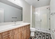 Thumbnail 11 of 37 - A bathroom with a sink, toilet, and shower.