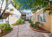 Thumbnail 10 of 12 - a courtyard between two buildings with trees and plants