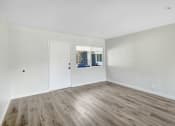 Thumbnail 10 of 47 - an empty living room with white walls and wood flooring